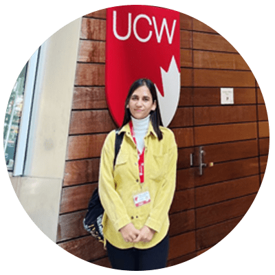 a woman standing in front of the ucw sign.